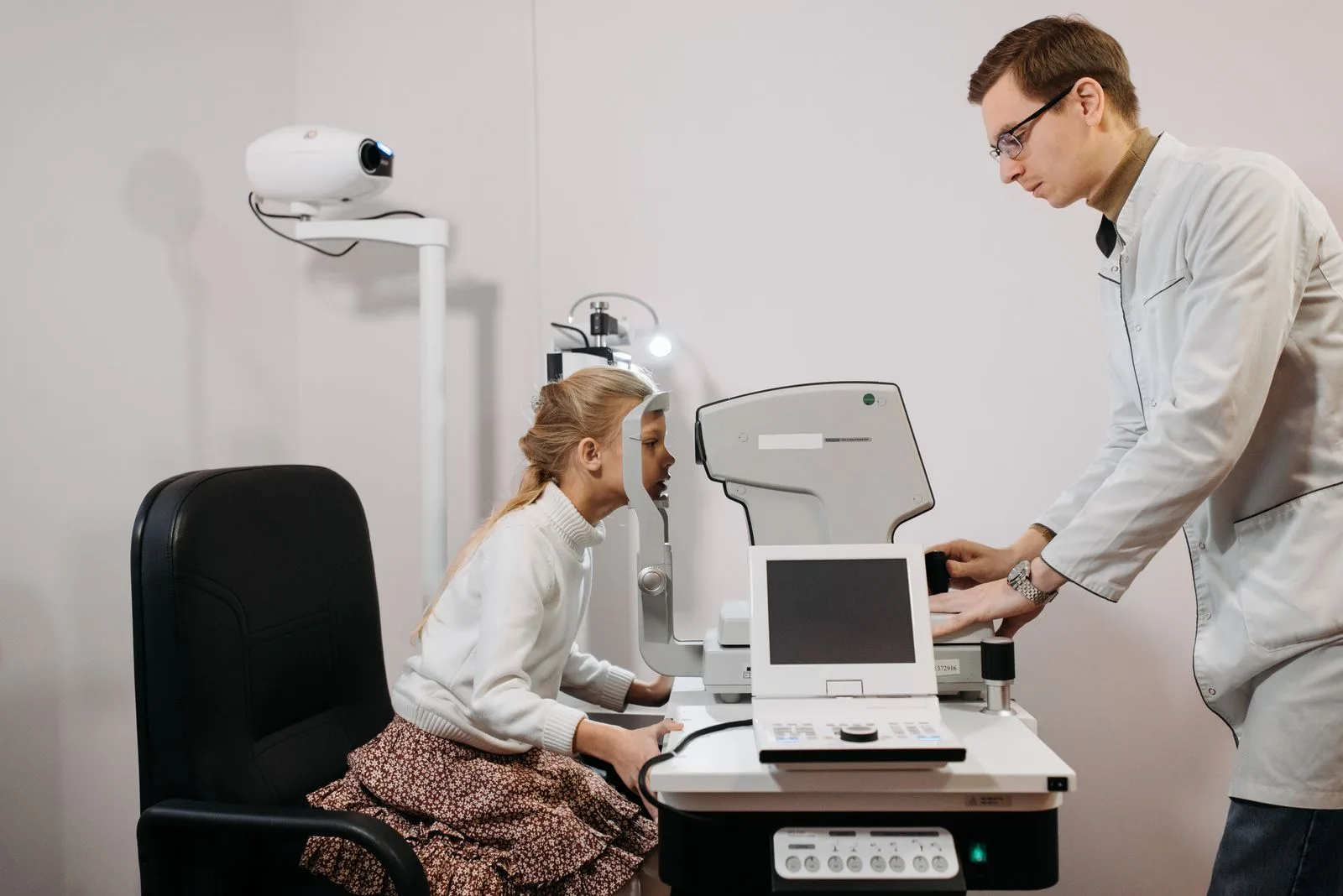 Jeune fille assise dans un fauteuil de consultation pendant un test de la vue