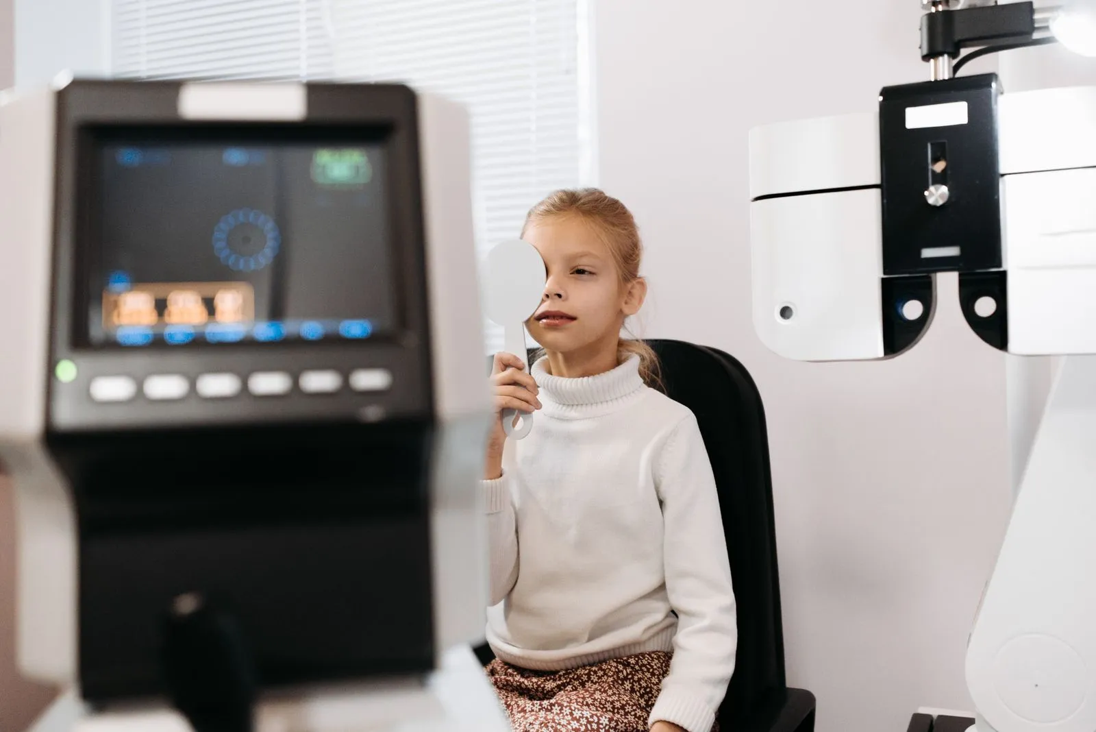 Jeune fille cachant un œil de la main pendant un test de la vue